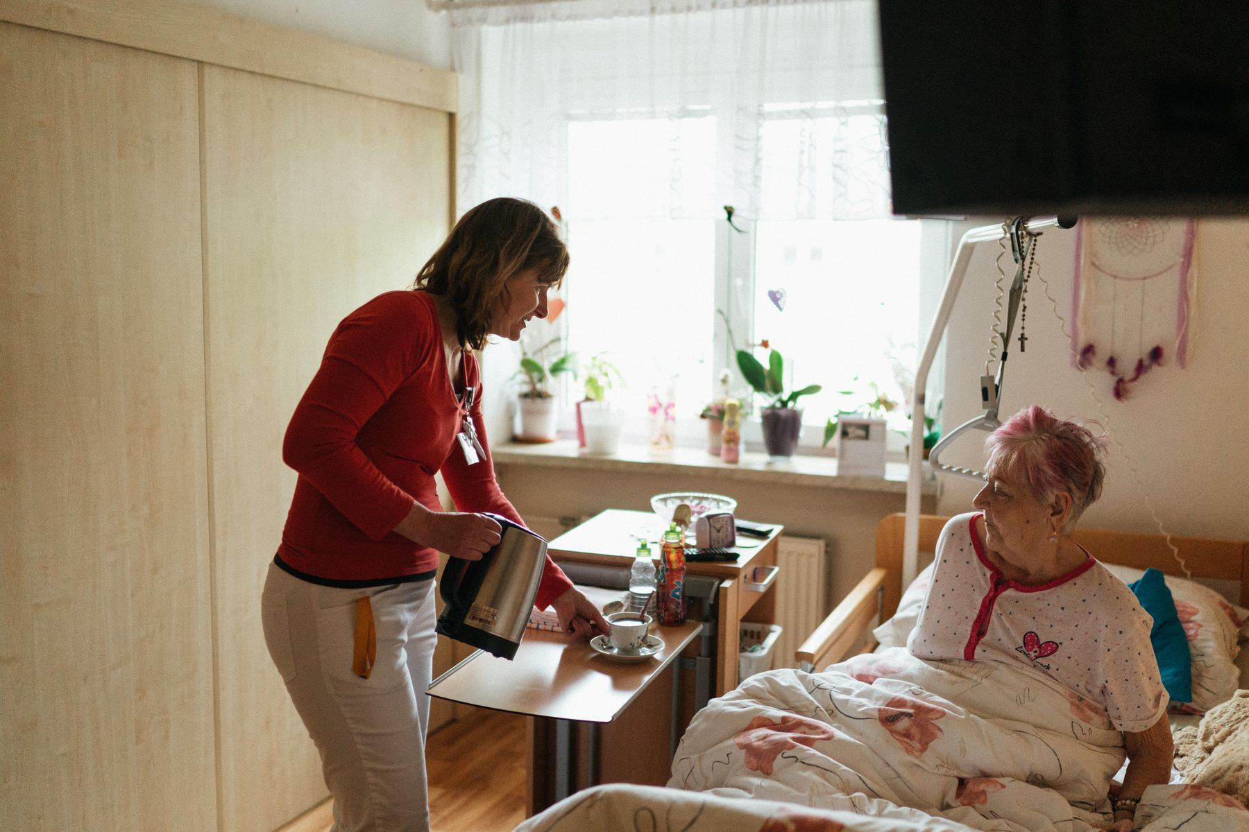 Caregiver bringing tea to a patient during a home visit